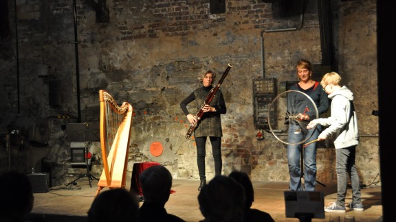 Vera Bühl macht Musik mit Hilfe eines Rades und zweier Personen aus dem Publikum