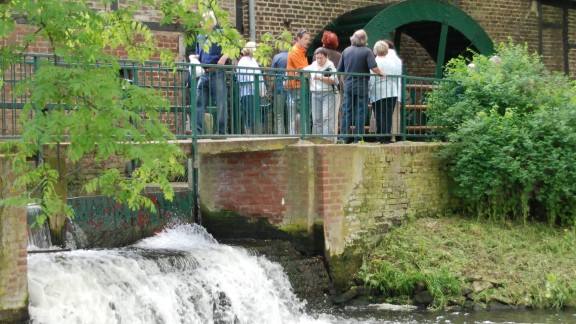 Gäste am Mühlentag am Wasserrad der Sindorfer Mühle.